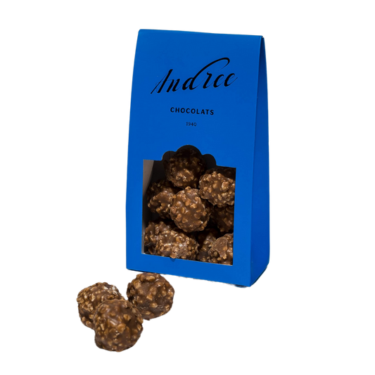 Ce paquet de rochers en chocolat de la marque Andrée Chocolats contient des boules de chocolat croquantes et garnies, offrant une expérience gourmande et texturée.